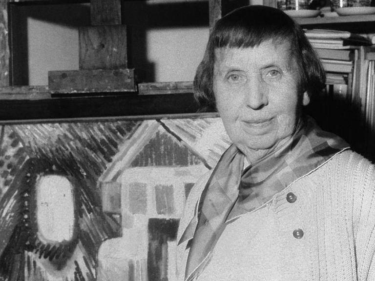 Die Malerin Ida Kerkovius 1959 in ihrem Stuttgarter Atelier vor der Staffelei. Neben Gemälden gehören zahlreiche Wandteppiche zu ihrem Werk. Ida Kerkovius wurde am 31. August 1879 (russischer Kalender) in Riga geboren und verstarb am 7. Juni 1970 in Stuttgart.