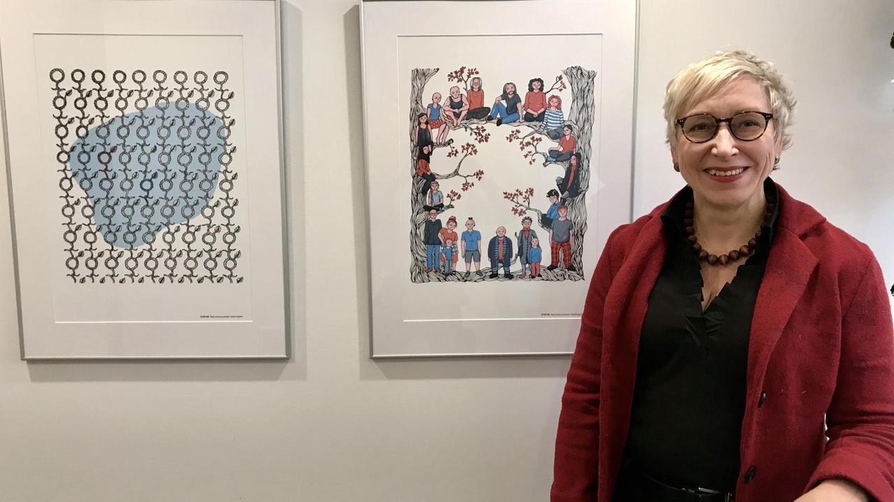 Porträt von Maria Kaisa Aula, Referatsleiterin im Ministerium für Soziales vor zwei Kunstwerken