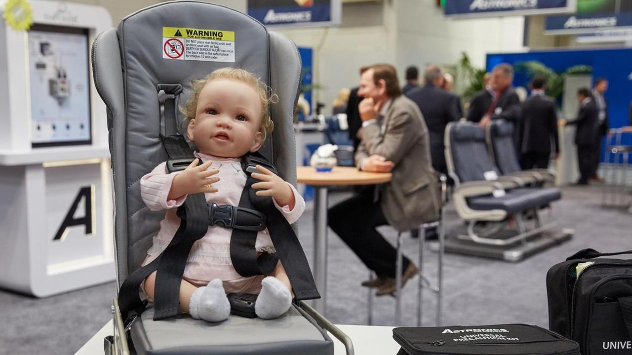 Ein Flugzeug-Baby-Sitz mit Puppe