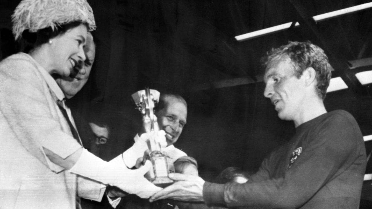 Queen Elizabeth II überreicht 1966 Englands Kapitain Bobby Moore den Weltmeisterpokal.