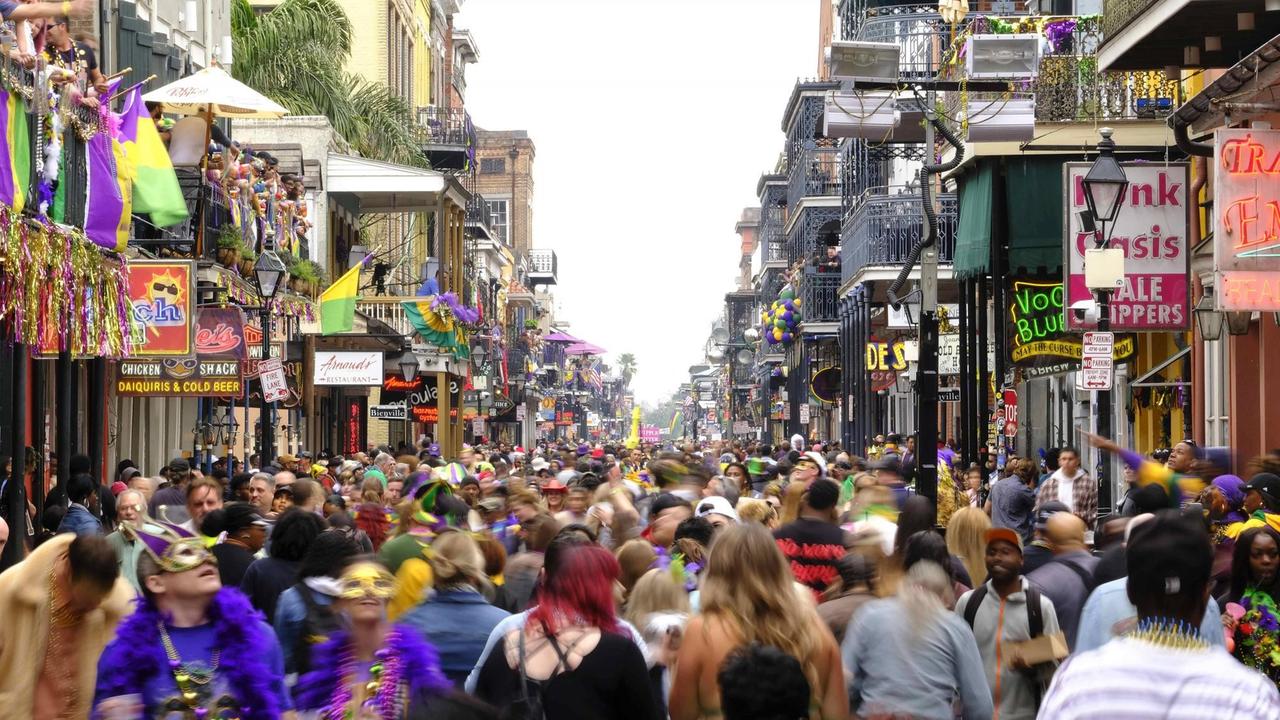 Hunderte Menschen drängen sich in einer kleinen Straße in New Orleans entlang.