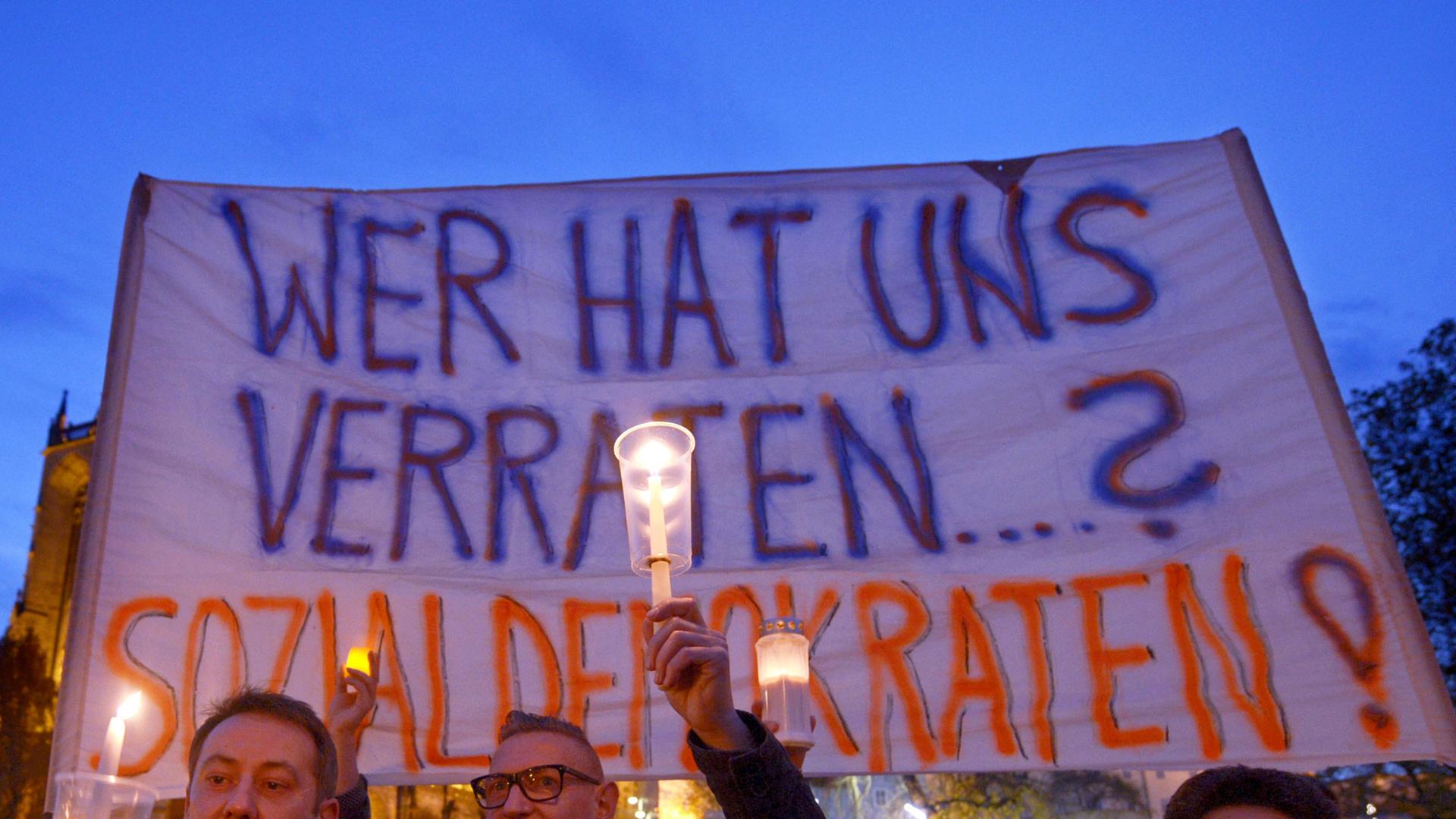 Teilnehmer einer Protestaktion gegen eine mögliche rot-rot-grüne Landesregierung in Thüringen halten auf dem Domplatz in Erfurt ein Banner mit der Aufschrift "Wer hat uns verraten...? Sozialdemokraten!" hoch.