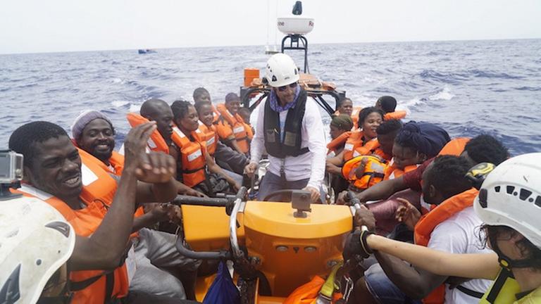 Das Foto zeigt eine Operation der Rettungsorganisation Sea Watch im Mittelmeer: Die geretteten Flüchtlinge sitzen in einem Schlauchboot.