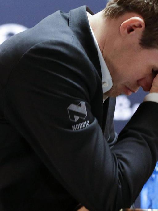 Magnus Carlsen vergräbt bei der Schach-Weltmeisterschaft 2016 beim Spiel in New York gegen Sergej Karjakin sein Gesicht in seiner Hand .