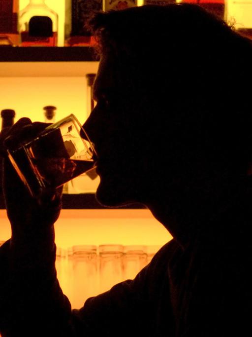 Ein Bar-Besucher trinkt ein Glas Whiskey