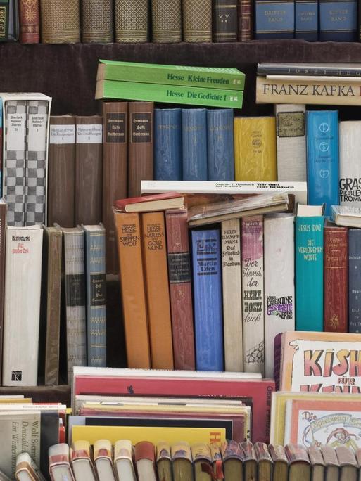 Alte Bücher stehen in der Auslage eines Antiquariats.