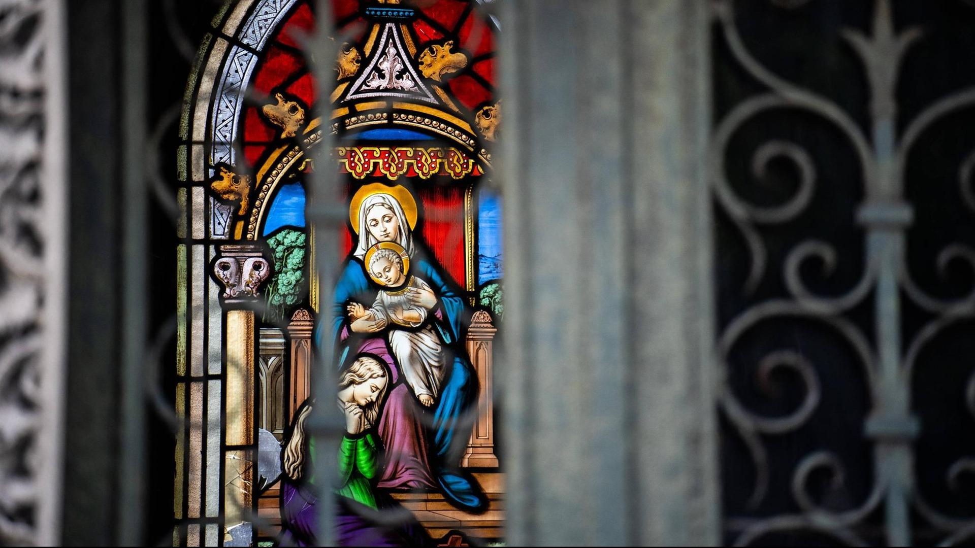 Detail eines farbigen Glasfensters mit der Jungfrau Maria mit Kind auf dem Friedhof Pere Lachaise in Paris.