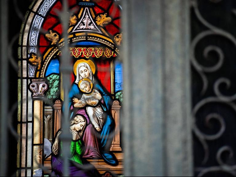 Detail eines farbigen Glasfensters mit der Jungfrau Maria mit Kind auf dem Friedhof Pere Lachaise in Paris.