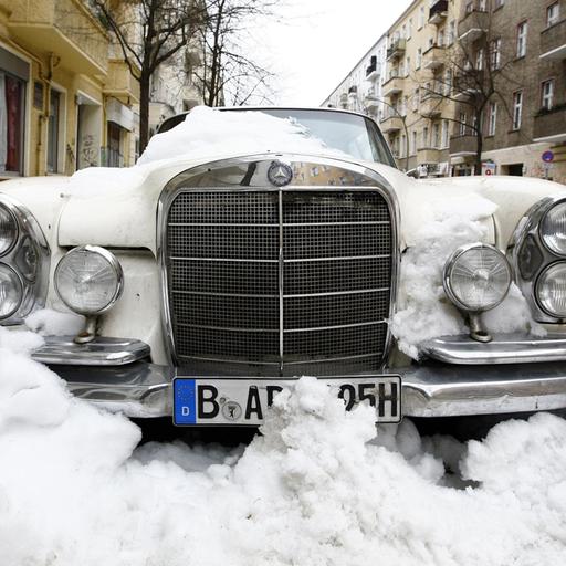 Ein eingeschneiter Oldtimer in Berlin Friedrichshain.