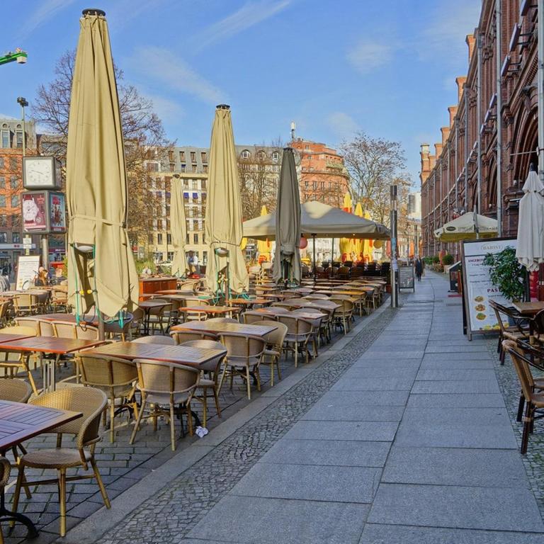 Wegen des Coronovirus verwaister Hackescher Markt mit leeren Restauranttischen und geschlossenen Sonnenschirmen am hellen Tag in Berlin-Mitte am 18.03.2020 