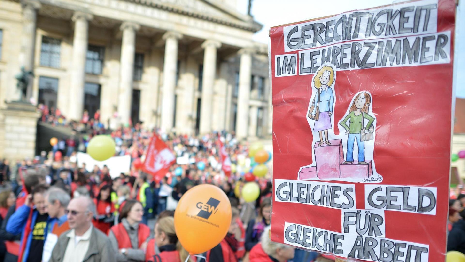 Auf einer Demonstration vor dem Berliner Reichstag ist ein Plakat mit der Aufschrift "Gerechtigkeit im Lehrerzimmer" zu sehen.