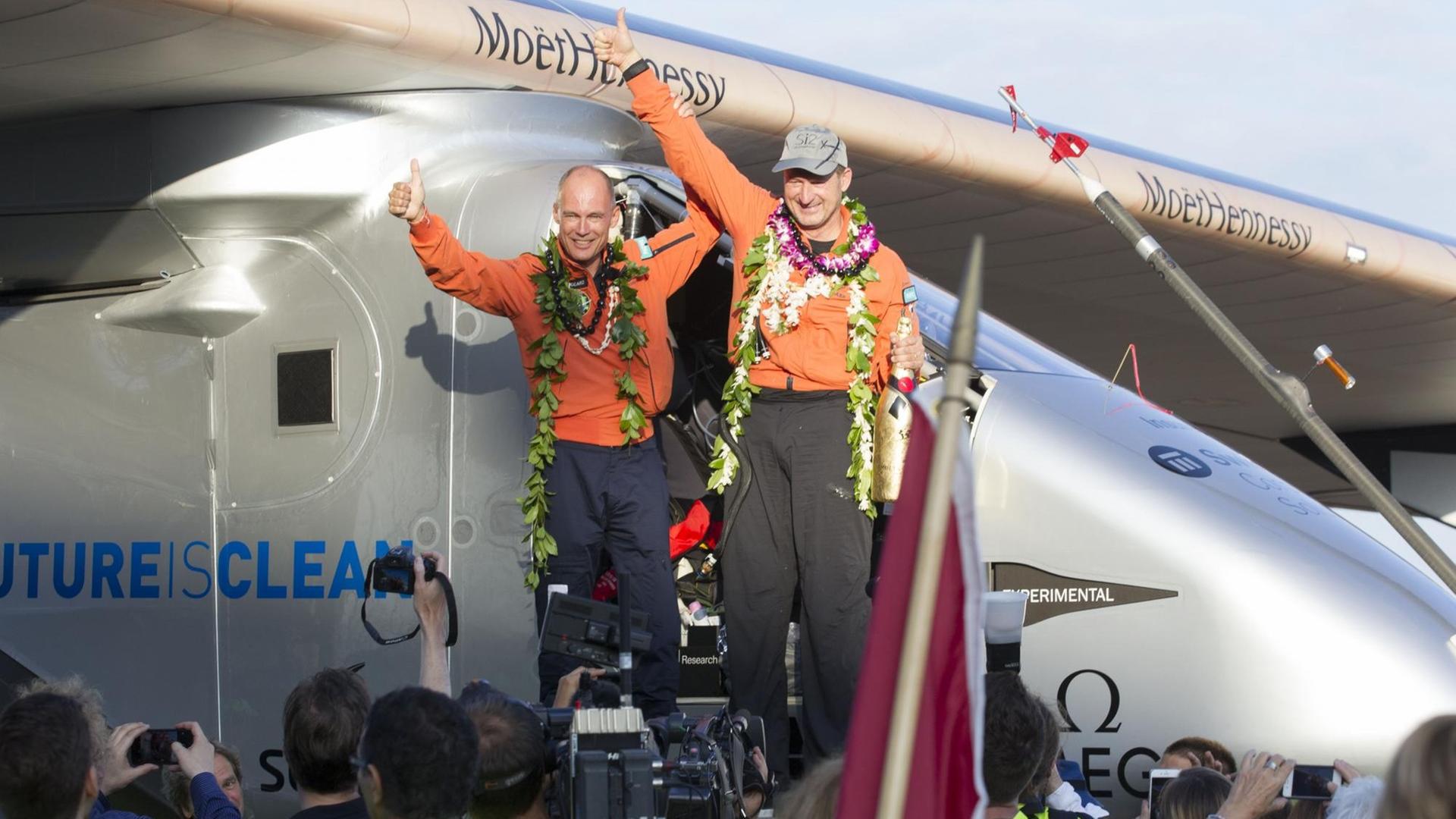 Pilot Bertrand Piccard (L) und Pilot Andre Borschberg feiern die Landung auf Haiwaii nach einem 120-Stunden-Flug von Japan.