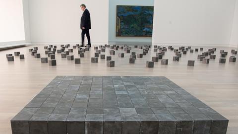 Ein Museumsmitarbeiter läuft bei der Eröffnung der Ausstellung «Wolke & Kristall» am 22.09.2016 in der Kunstsammlung in Düsseldorf durch die Installation «Wolke & Kristall» von Carl Andre.