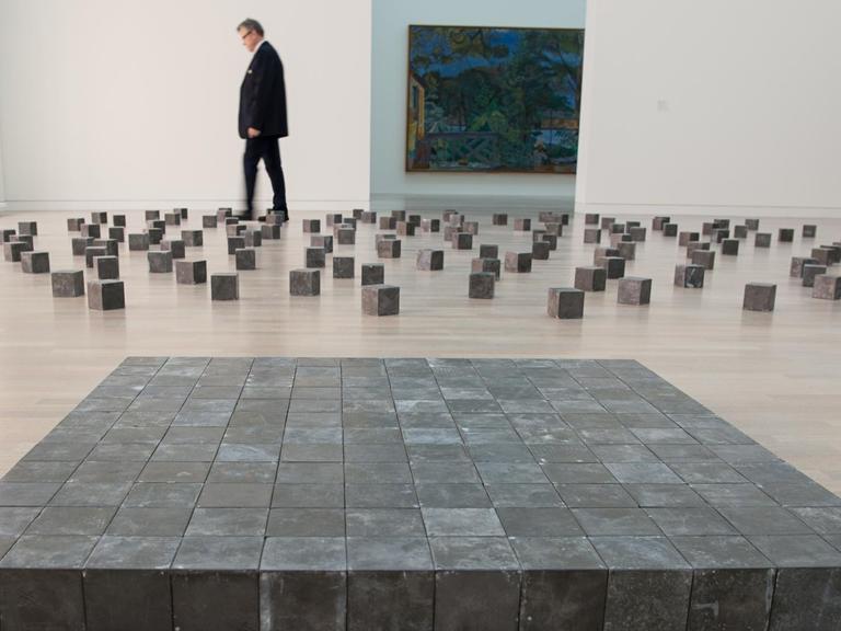 Ein Museumsmitarbeiter läuft bei der Eröffnung der Ausstellung «Wolke & Kristall» am 22.09.2016 in der Kunstsammlung in Düsseldorf durch die Installation «Wolke & Kristall» von Carl Andre.