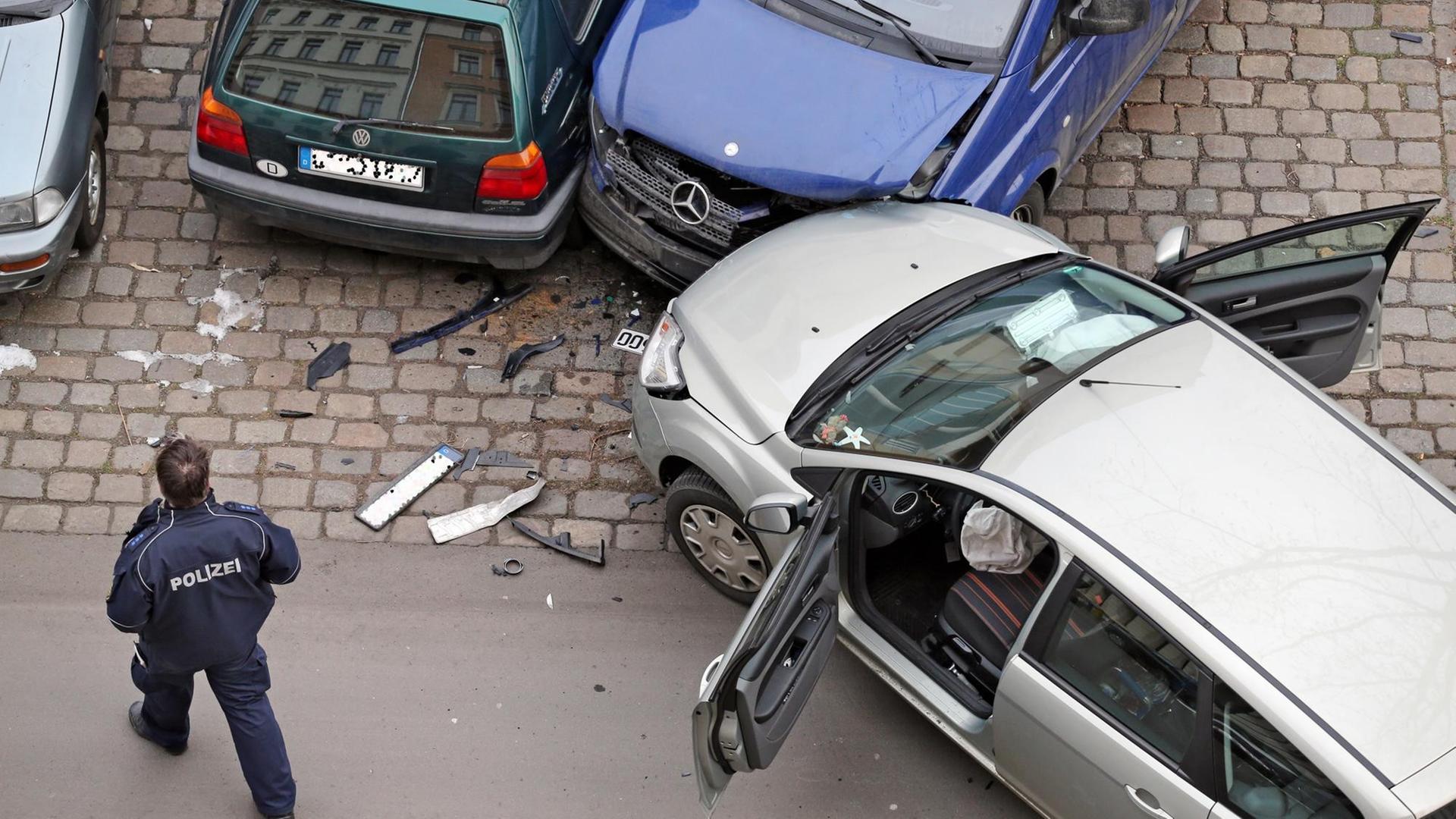 Ein Polizist nimmt am 29.01.2014 einen Verkehrsunfall an dem ein Ford Focus, ein VW Golf 3 und ein Mercedes Transporter Viano beteiligt sind in Leipzig (Sachsen) auf. Foto: Jan Woitas | Verwendung weltweit
