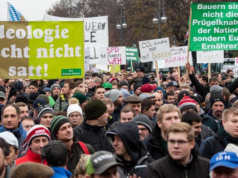 Viele Bauern stehen bei einer Protestaktion gegen das Agrarpaket der Bundesregierung auf der Straße des 17. Juni vor dem Brandenburger Tor und halten Plakate mit der Aufschrift "Ideologie macht nicht satt" und "Bauern sind nicht die Prügelknaben der Nation, sondern Eure Ernährer!".