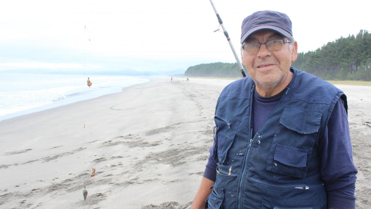 Angler José Nuñez steht am Strand neben der Fabrik von Arauco.
