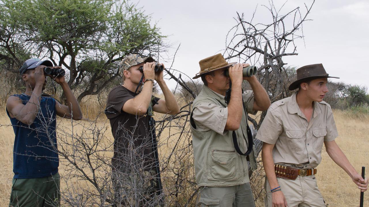 Konzentriert auf die Beute: Vier Jäger mit Fernrohr im Film "Safari" von Ulrich Seidl