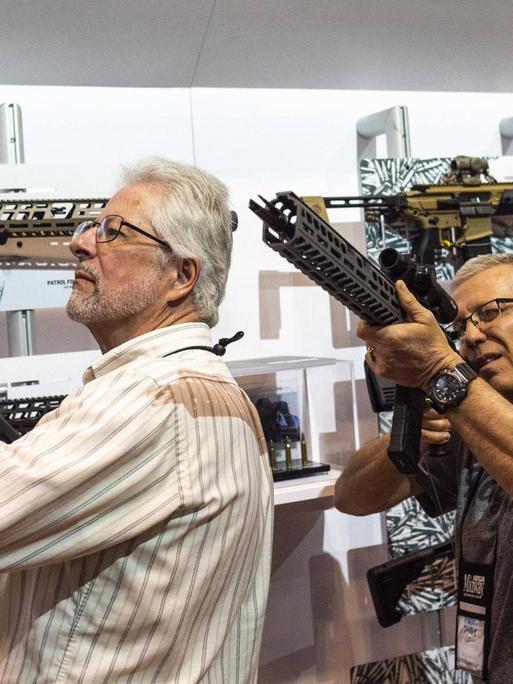 Besucher der NRA-Jahresversammlung begutachten Waffen.