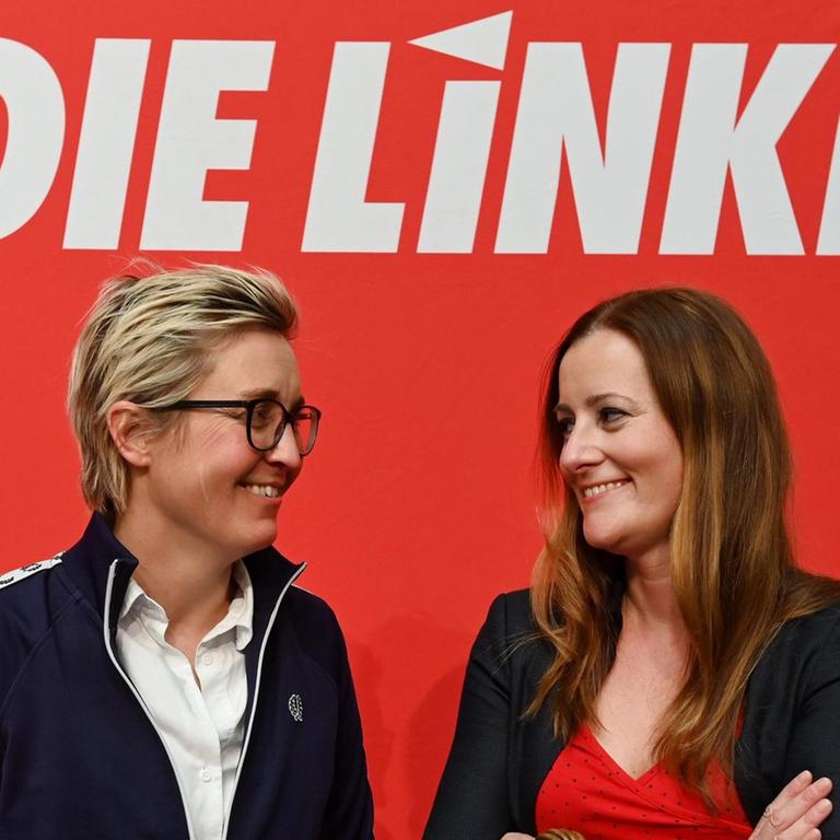 Susanne Hennig-Wellsow (l), Landesvorsitzende von Die Linke Thüringen, und Janine Wissler, stellvertretende Parteivorsitzende der Linken auf Bundesebene, stehen auf dem Landesparteitag der Linken Thüringen zusammen und lächeln