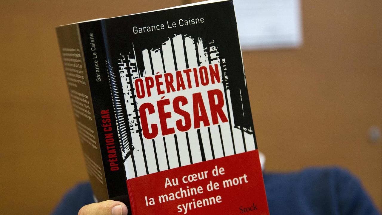 Ein Mann liest das Buch "Codename Caesar" von Garance Le Caisne. Eine Recherche über die Foltermethoden des syrischen Regimes.Baschar al-Assad Syrien Militärfotograf