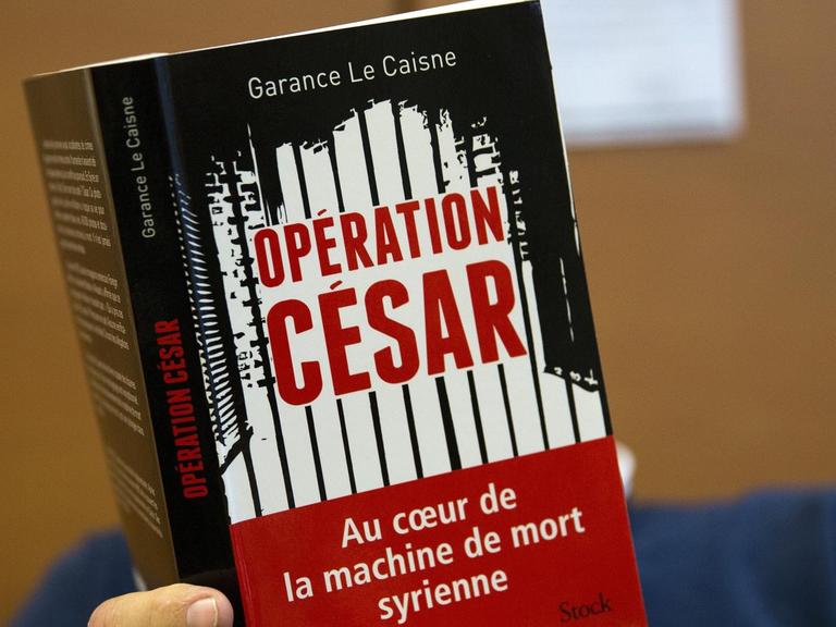 Ein Mann liest das Buch "Codename Caesar" von Garance Le Caisne. Eine Recherche über die Foltermethoden des syrischen Regimes. Baschar al-Assad Syrien Militärfotograf