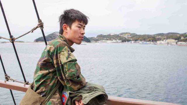 Kei im Militärstil-Camouflage-Hemd auf einem Schiff vor der japanischen Insel Awaji