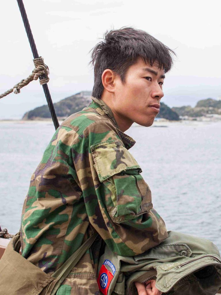 Kei im Militärstil-Camouflage-Hemd auf einem Schiff vor der japanischen Insel Awaji