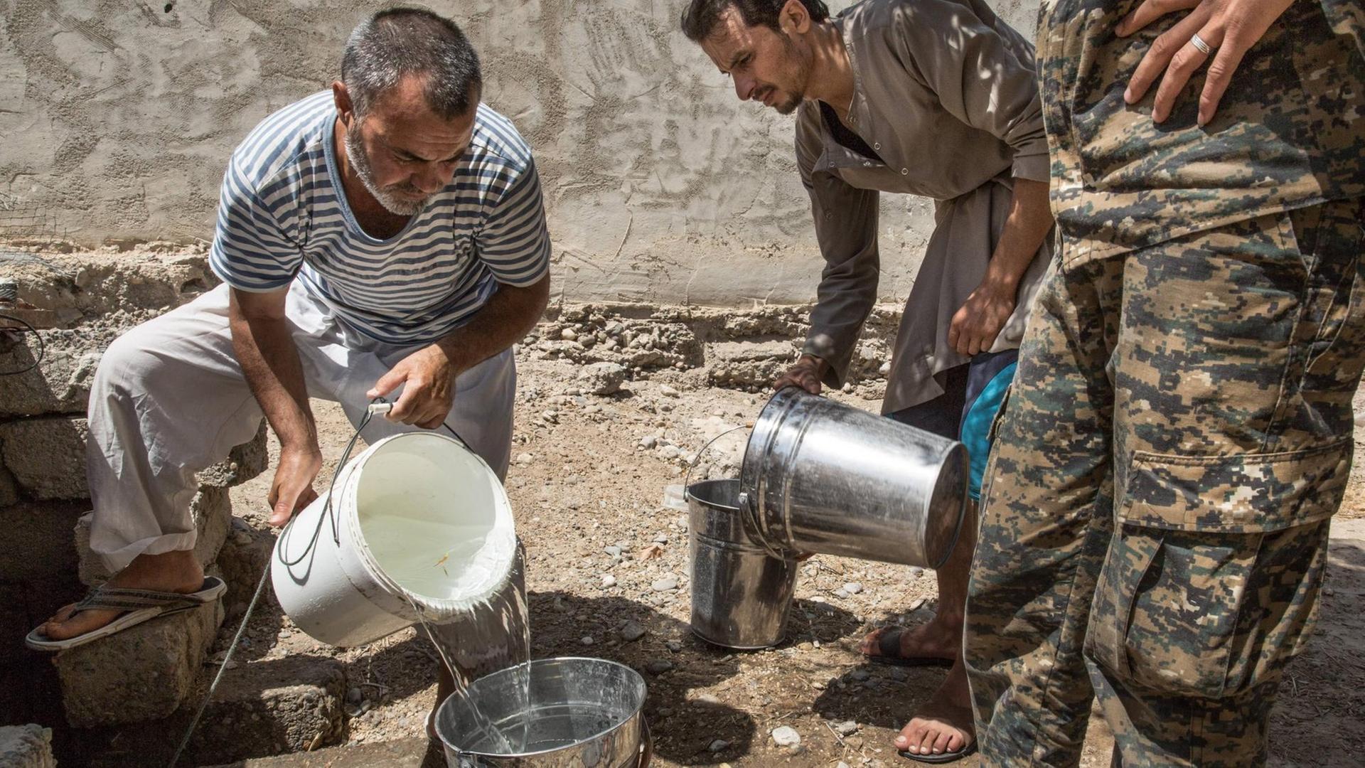 Knappes Gut: Soldaten gießen Wasser in Eimer in Rakka, Syrien.
