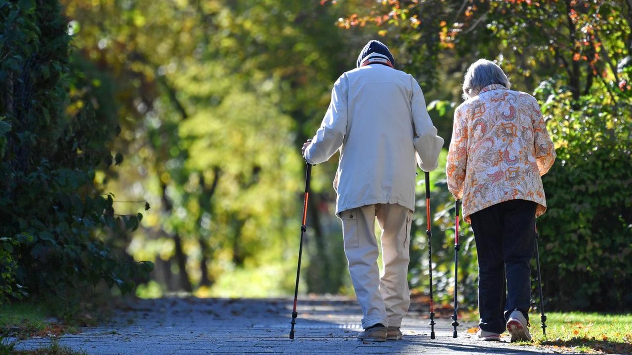 Ein alter Mann und eine alte Frau gehen spazieren. 