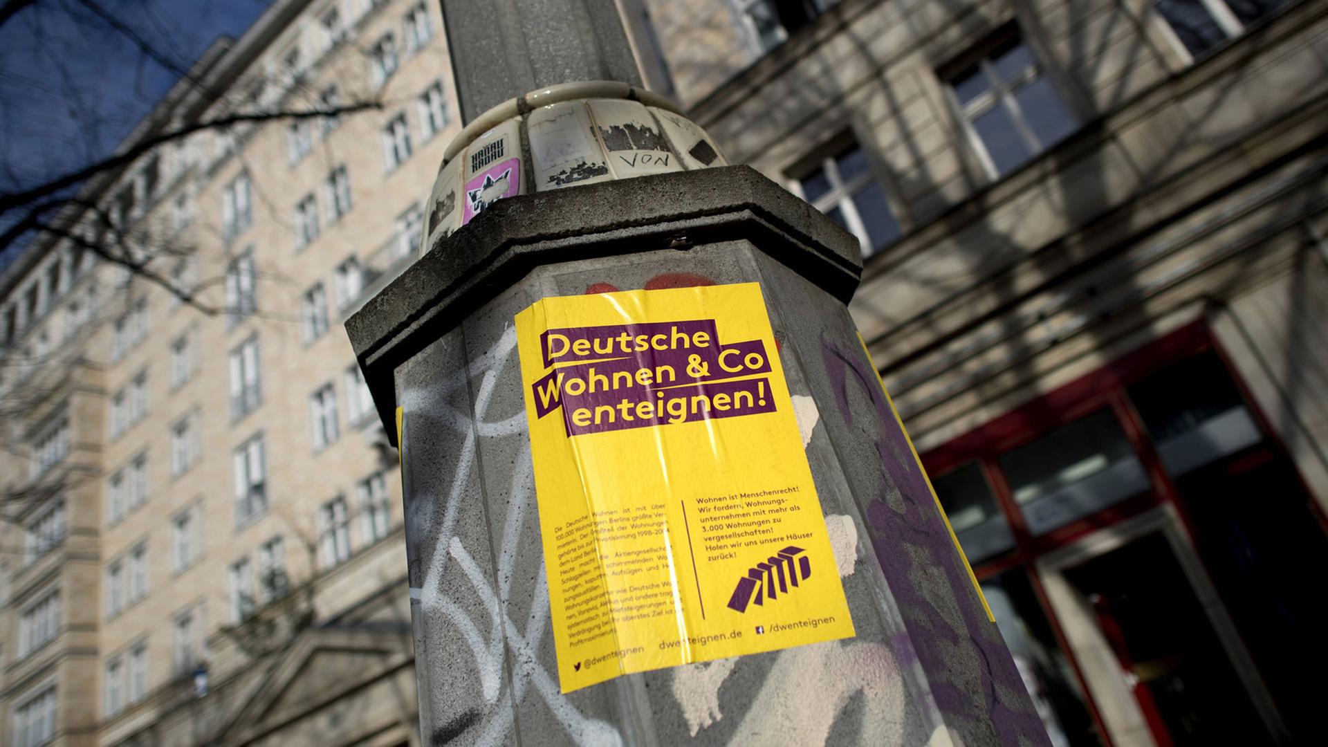 Protestplakat "Deutsche Wohnen und Co enteignen" an einem Wohnhaus an der Karl-Marx-Allee in Berlin-Friedrichshain.