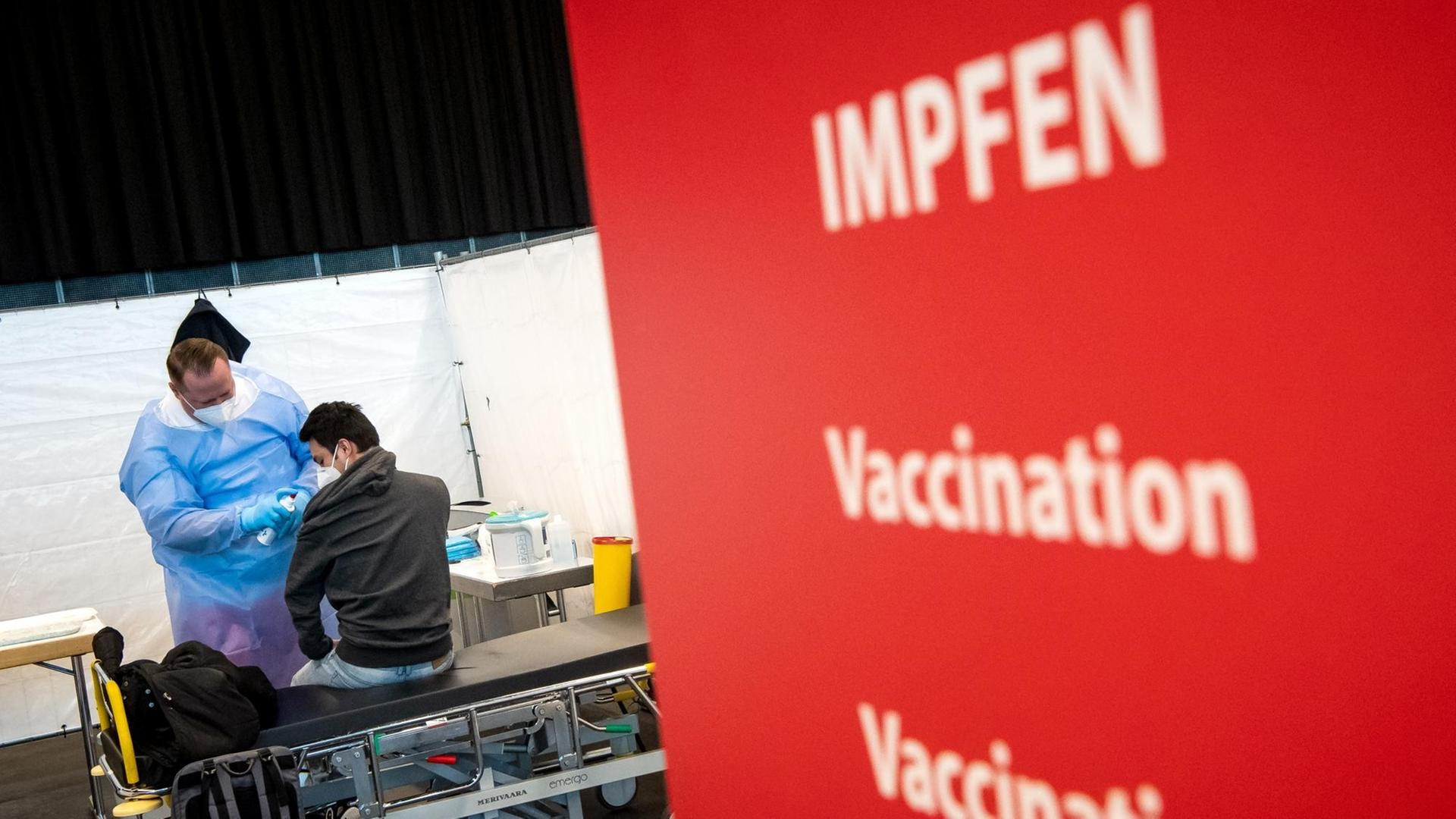 Ein Mann wird im Bremer Impfzentrum geimpft. Das Impfzentrum Bremen in der Messehalle 7 hat den Betrieb aufgenommen.