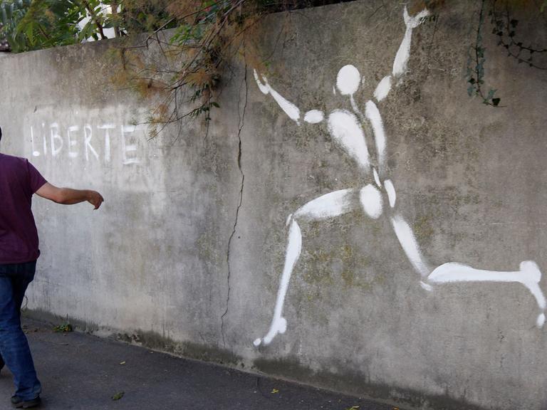 Der französische Künstler Jerome Mesnager geht an einem seiner Kunstwerke, dem "Mann in Weiß", in Montreuil-sous-Bois vorbei.