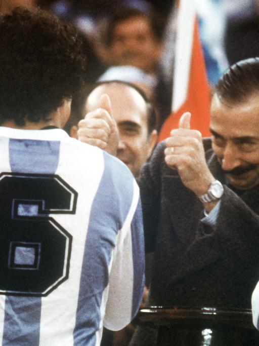 Der argentinische Junta-Chef, General Jorge Videla (2.v.r.), freut sich. Er überreicht bei der Siegerehrung am 25.06.1978 im River Plate-Stadion in Buenos Aires den WM-Pokal an Argentiniens Kapitän Daniel Passarella (r), der von seinem Teamgefährten Americo Gallego (Nr. 6) flankiert wird.