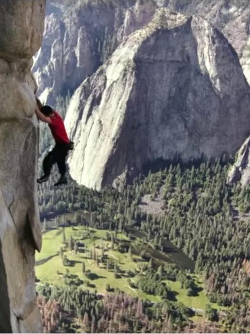 Szene aus dem Film "Free Solo". Man sieht einen Kletterer in einer Felswand, unter ihm das Tal.