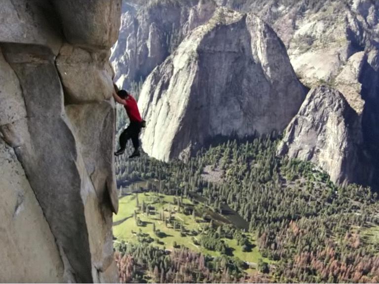 Szene aus dem Film "Free Solo". Man sieht einen Kletterer in einer Felswand, unter ihm das Tal.