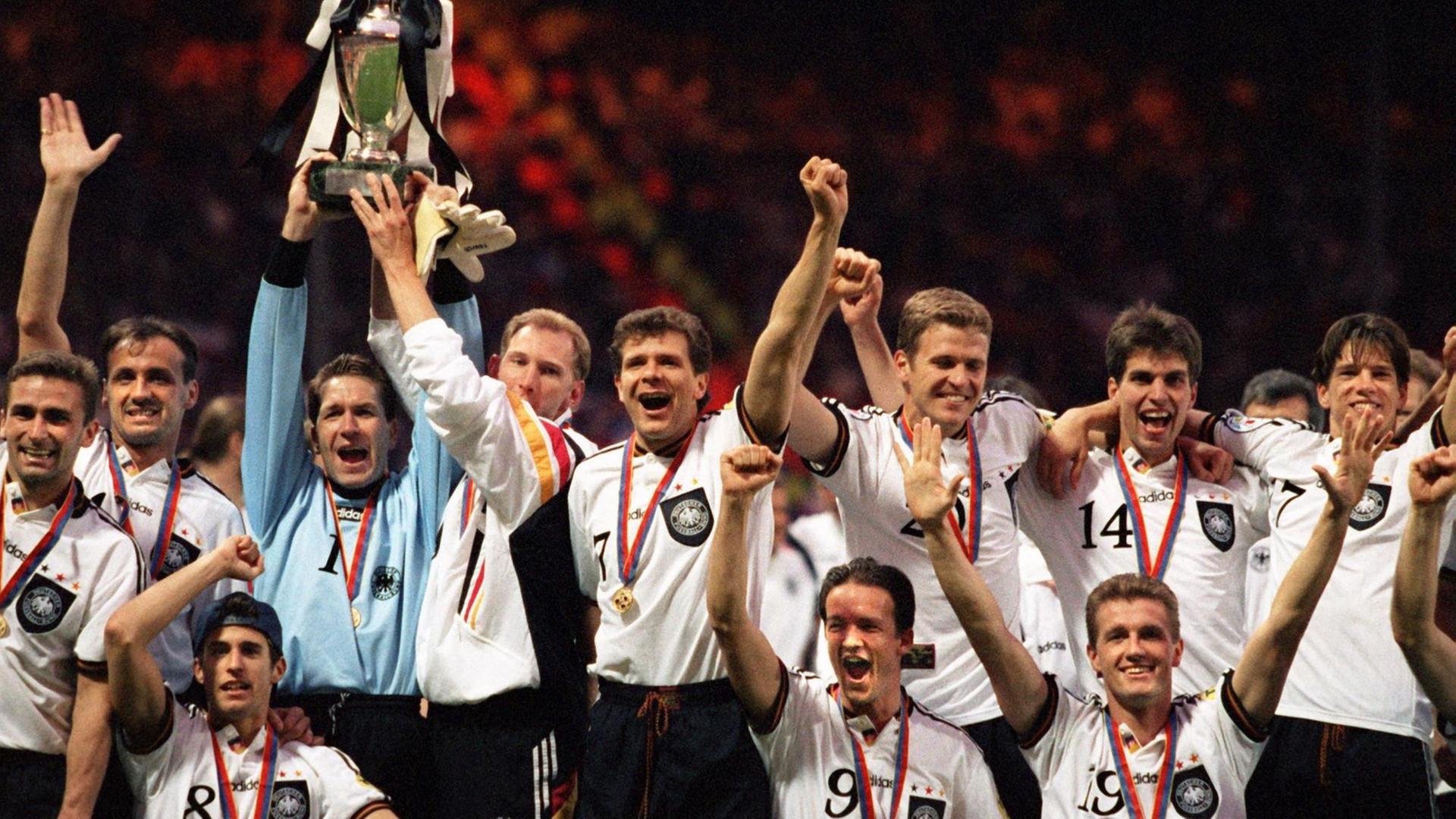 Jubel mit der EURO '96-Trophäe: Nationalspieler Stefan Kuntz, Jürgen Kohler, Mehmet Scholl, Andreas Köpke, Dieter Eilts, Andreas Möller, Fredi Bobic, Oliver Bierhoff, Thomas Strunz, Markus Babbel und Christian Ziege. Jubel mit der EURO '96-Trophäe: Nationalspieler Stefan Kuntz, Jürgen Kohler, Mehmet Scholl, Andreas Köpke, Dieter Eilts, Andreas Möller, Fredi Bobic, Oliver Bierhoff, Thomas Strunz, Markus Babbel und Christian Ziege.