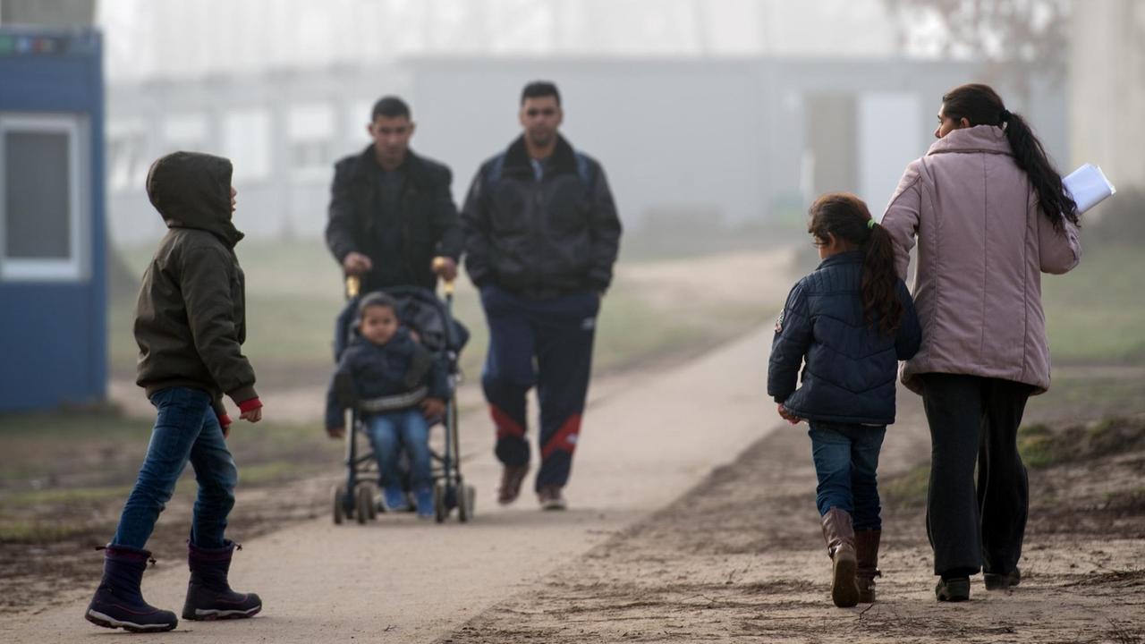 Flüchtlinge und ihre Kinder gehen über das Gelände der Zentralen Ausländerbehörde in Eisenhüttenstadt (Brandenburg).