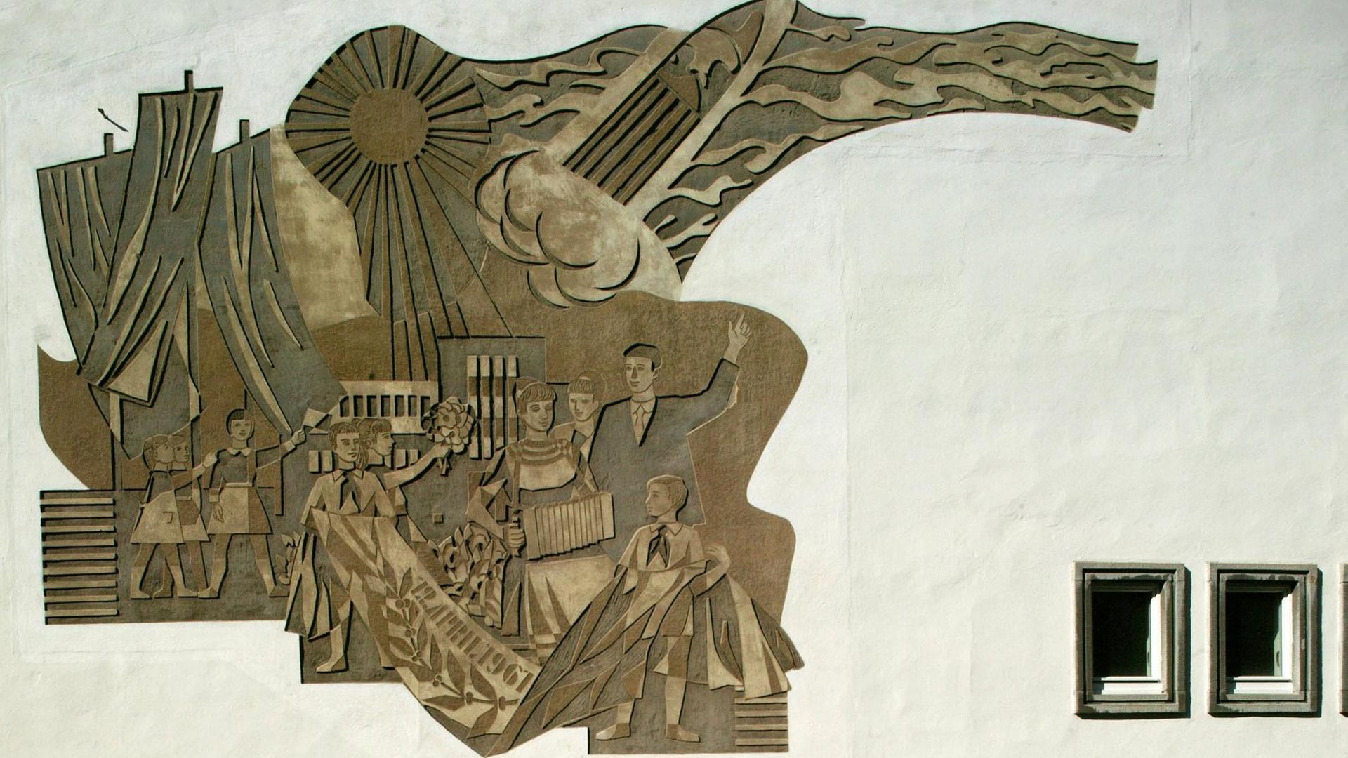 Dieses Sgrafitto an einer Fassade ist auch in der DDR als Kunst am Bau entstanden und stellt den sowjetischen Kosmonauten Juri Gagarin und FDJ-Mitglieder dar. Dieses Sgrafitto an einer Fassade ist auch in der DDR als Kunst am Bau entstanden und stellt den sowjetischen Kosmonauten Juri Gagarin und FDJ-Mitglieder dar.