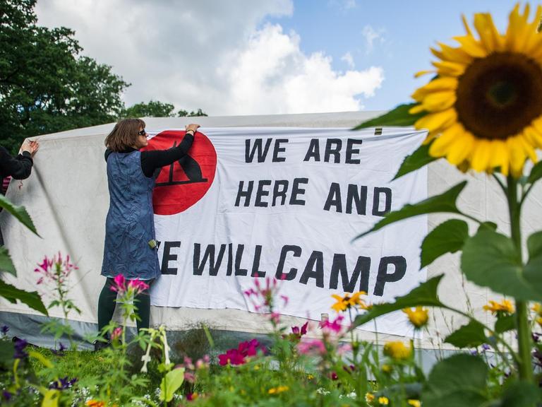 Unterstützer des Antikapitalistischen Camps befestigen am 26.06.2017 in Hamburg ein Banner mit der Aufschrift "We are here and we will camp" auf einem Zelt im Eingang des Stadtparks. Im Rahmen einer Mahnwache gegen die Entscheidung des Hamburgischen Oberverwaltungsgerichts, ein Camp im Stadtpark sei keine vom Grundgesetz geschützte Versammlung und somit verboten, protestieren einige G20-Gegner. Das Hamburgische Oberverwaltungsgericht hatte seine Entscheidung am 23.06.2017 verkündet.
