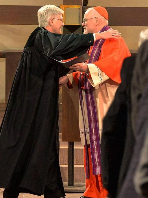 Der Ratsvorsitzende der Evangelischen Kirche in Deutschland Heinrich Bedford-Strohm und der Vorsitzende der katholischen Deutschen Bischofskonferenz Kardinal Reinhard Marx umarmen einander bei einem Gottesdienst in Hildesheim im März 2017