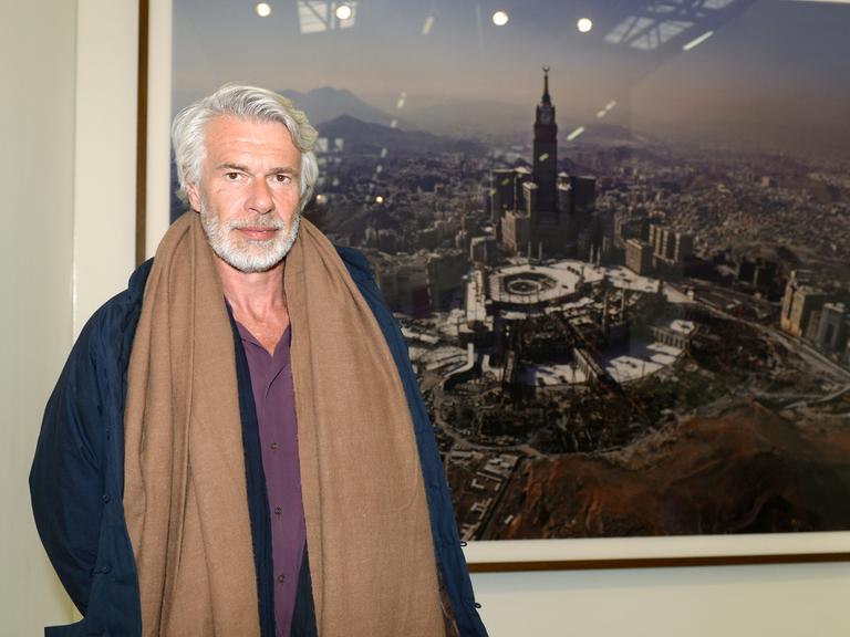 Chris Dercon, Direktor der Tate Gallery of Modern Art in London, auf der New Yorker Kunstmesse "The Armory Show" vor einem Bild des Künstlers Ahmed Mater, das die Stadt Mekka zeigt.