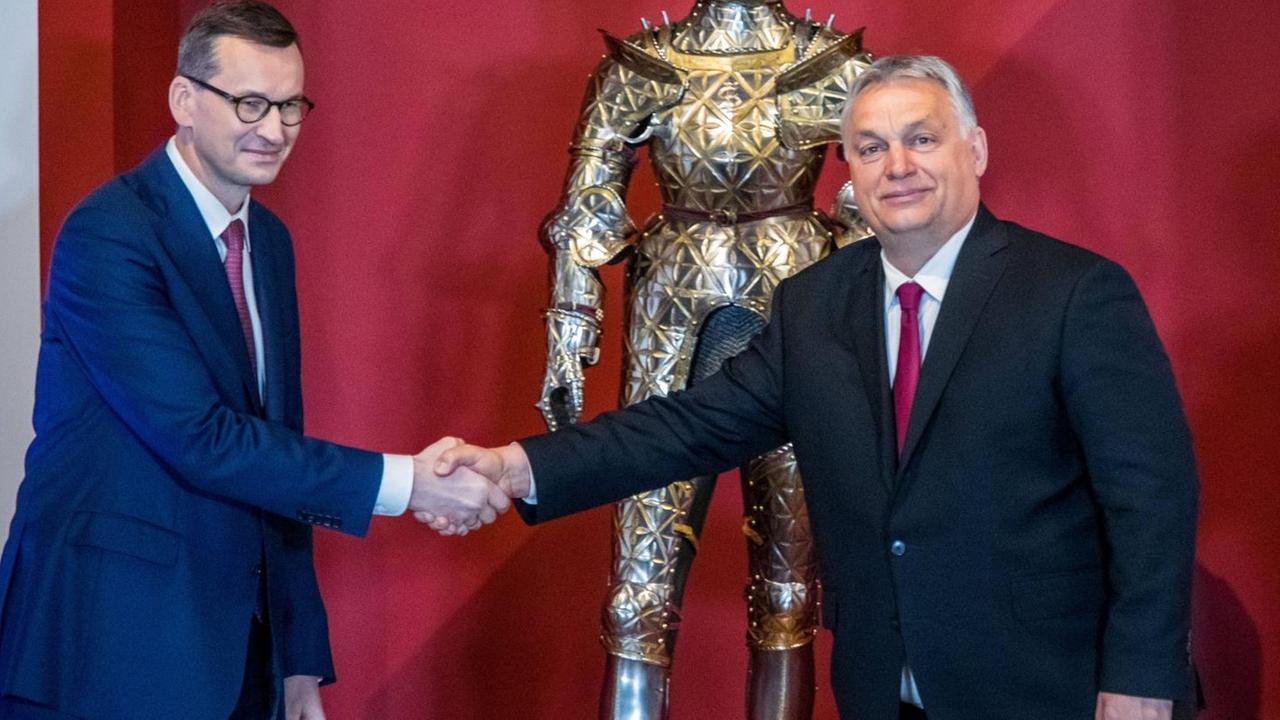 Der polnischen Ministerpräsident Mateusz Morawiecki und der ungarische Ministerpräsident Victor Orban (r.) reichen sich die Hand