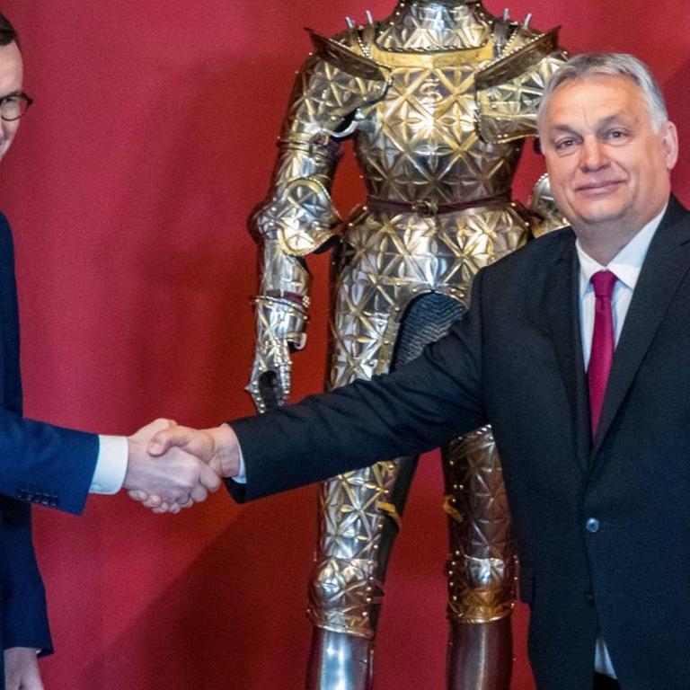 Der polnischen Ministerpräsident Mateusz Morawiecki und der ungarische Ministerpräsident Victor Orban (r.) reichen sich die Hand