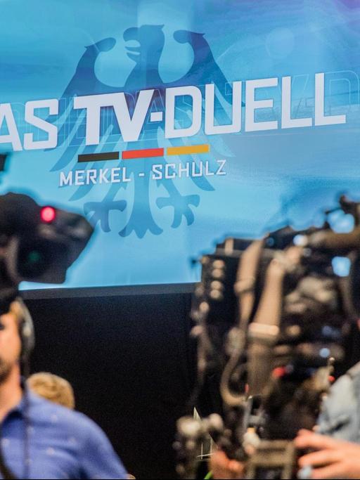 Kameras filmen im Fernsehstudio Adlershof die Pressekonferenz zum TV-Duell anlässlich der Bundestagswahl 2017. Im Hintergrund das Logo des TV-Duells an einer Wand zu sehen.