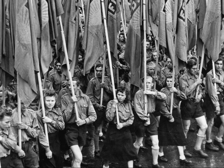 Mitglieder der "Freien Deutschen Jugend" tragen Fahnen der FDJ auf dem Weg zum Lustgarten in Berlin Mitglieder der "Freien Deutschen Jugend" tragen Fahnen der FDJ auf dem Weg zum Lustgarten in Berlin