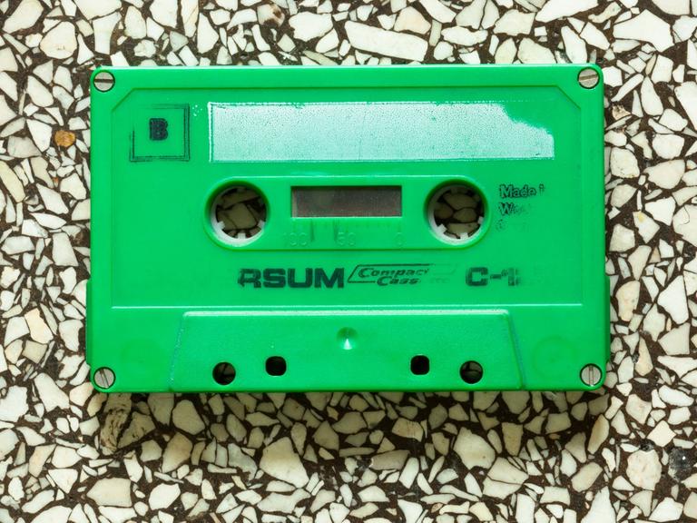 Eine grüne Musikkassette liegt auf einem Steinboden