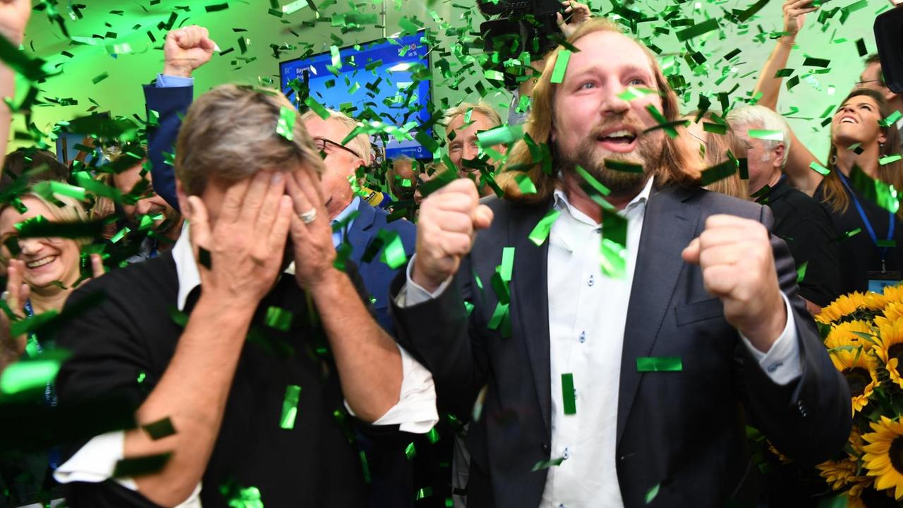 Der Bundesvorsitzende von Bündnis 90/Die Grünen Robert Habek und Anton Hofreiter, Vorsitzender der Bundesfraktion (l-r), jubeln im Landtag nach den ersten Wahlergebnissen.