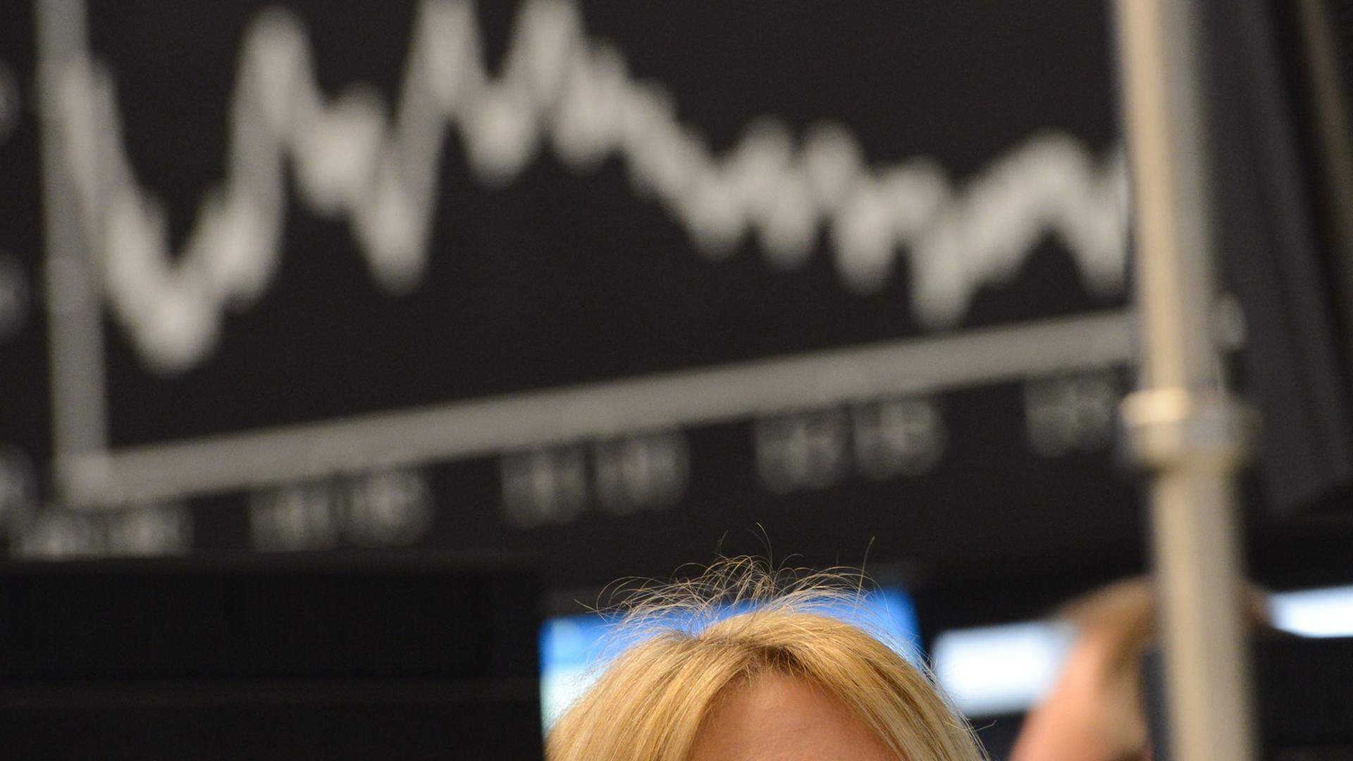 Eine Börsenhändlerin beobachtet auf dem Parkett der Wertpapierbörse in Frankfurt am Main ihre Monitore, die Verluste anzeigen.