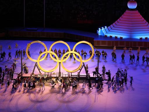 Japan, Tokio: Olympia: Eröffnungsfeier im Olympiastadion. Olympische Ringe werden während der Show zusammengeführt.